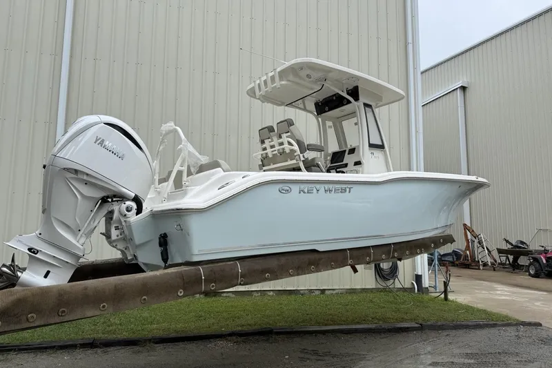 Slide: The Image of 2026 Key West 239 FS boat lifted by forklift near a large building. - 1