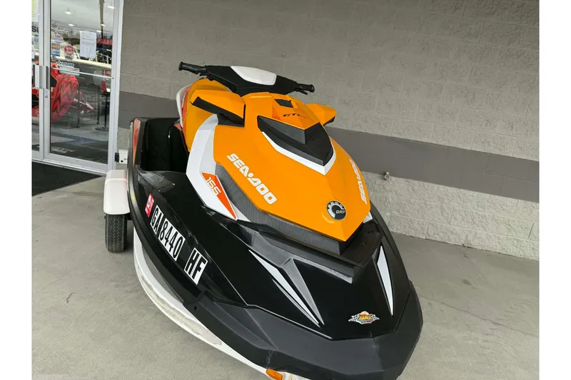 Slide: The Image of 2018 Seadoo GTI SE 155 jet ski in vibrant orange and black, parked outside a store. - 12