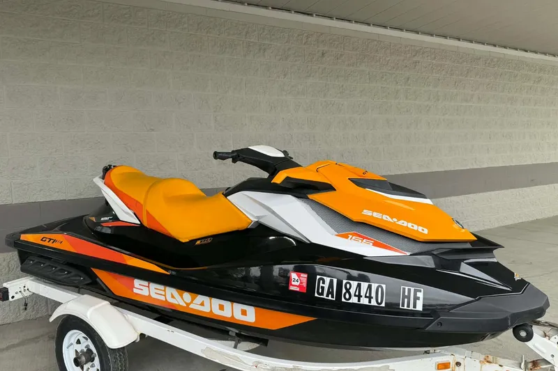 Slide: The Image of 2018 Seadoo GTI SE 155 jet ski with orange and black design on a trailer. - 15
