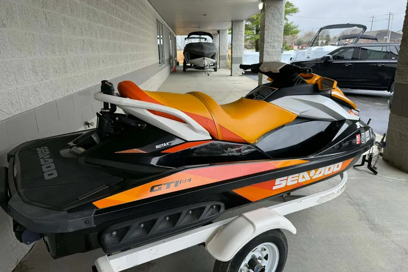 Slide: The Image of 2018 Seadoo GTI SE 155 jet ski on trailer, vibrant orange and black design. - 2