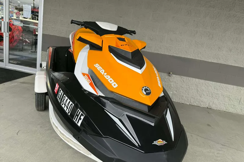 Slide: The Image of 2018 Seadoo GTI SE 155 jet ski in black and orange, parked outside a store. - 3