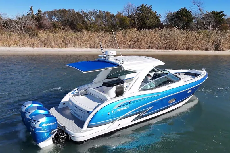 The Image of 2019 Formula 350 Crossover Bowrider OB cruising near a sandy shoreline. - 0