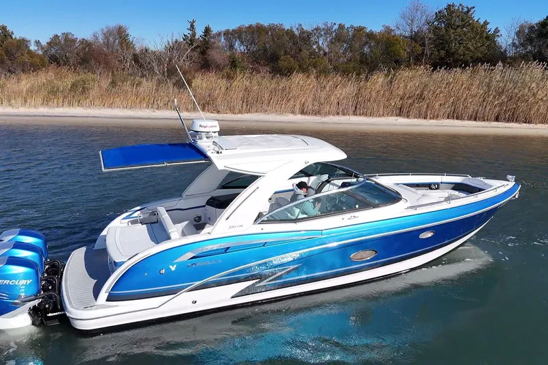 Slide: The Image of 2019 Formula 350 Crossover Bowrider OB cruising near a sandy shoreline. - 2