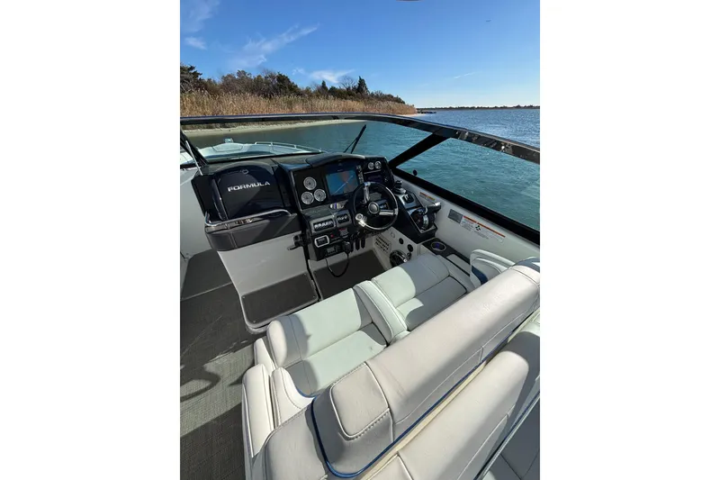 Slide: The Image of 2019 Formula 350 Crossover Bowrider OB cockpit with modern controls, on a serene waterway. - 47