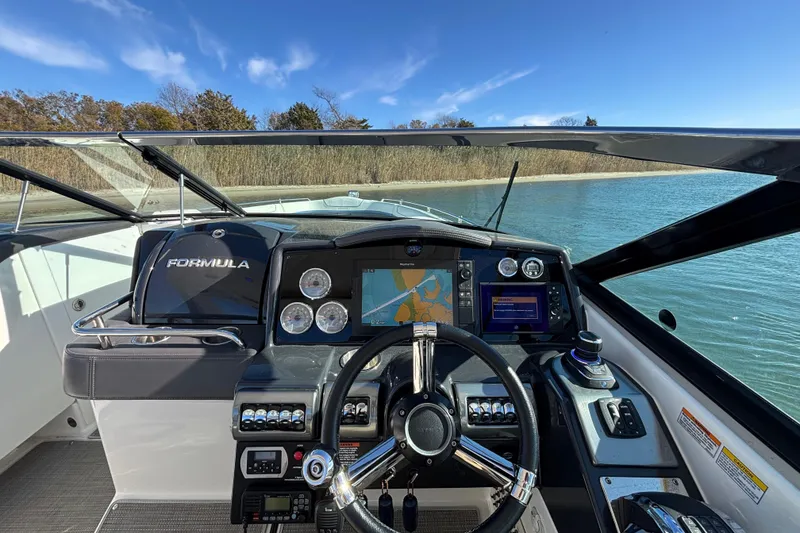 Slide: The Image of 2019 Formula 350 Crossover Bowrider OB dashboard with navigation screens and steering wheel. - 49