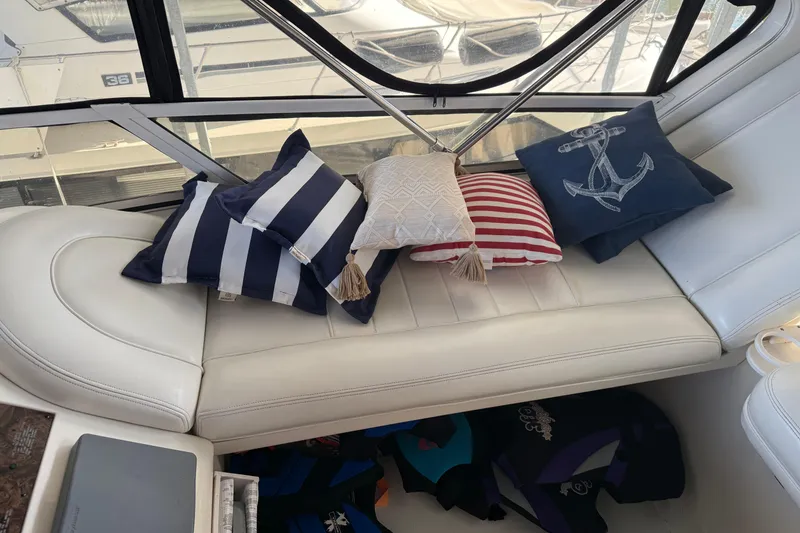 Slide: The Image of 1997 Sea Ray 370 Aft Cabin interior with nautical-themed cushions on white seating. - 19
