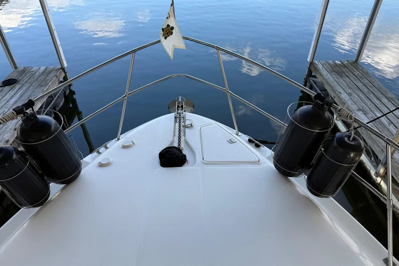 Slide: The Image of Bow view of 1997 Sea Ray 370 Aft Cabin docked, with fenders and calm water. - 23