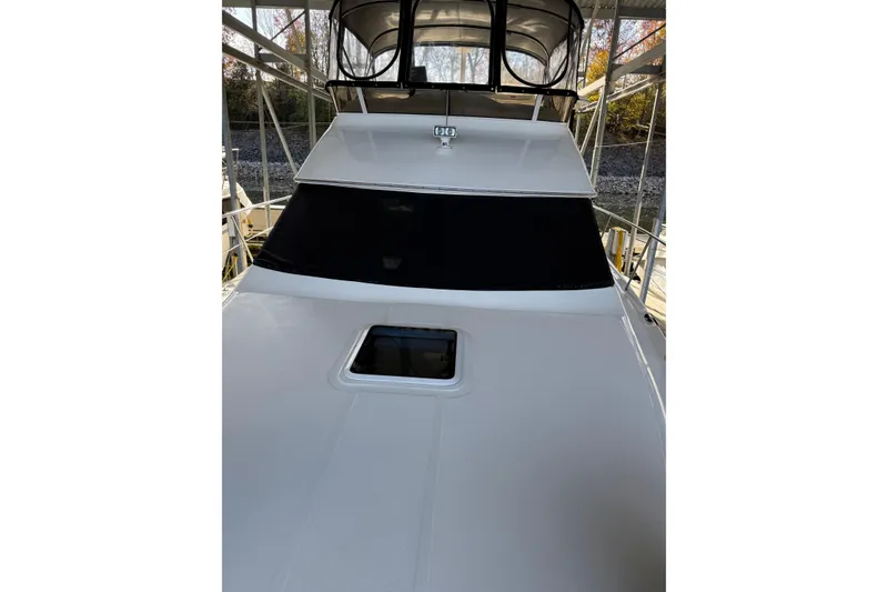 Slide: The Image of 1997 Sea Ray 370 Aft Cabin yacht with covered flybridge, docked in a marina. - 24