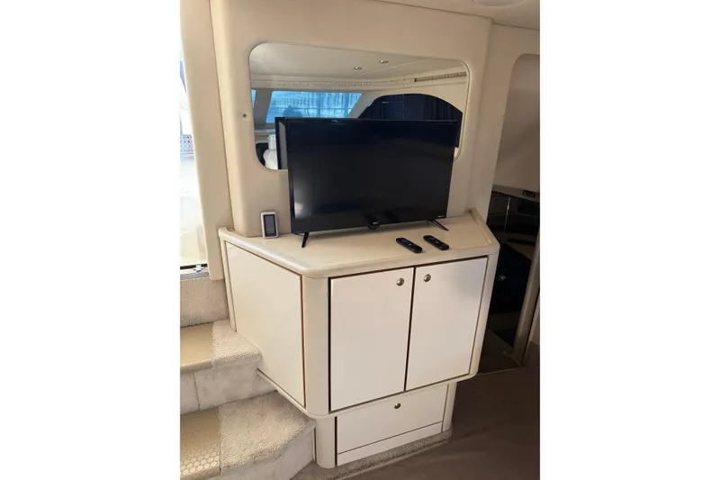 Slide: The Image of 1997 Sea Ray 370 Aft Cabin interior with TV, cabinet, and stairs. - 27
