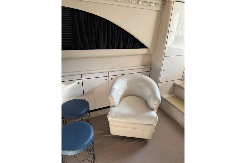 Slide: The Image of Interior of 1997 Sea Ray 370 Aft Cabin with white chair and blue stools. - 28