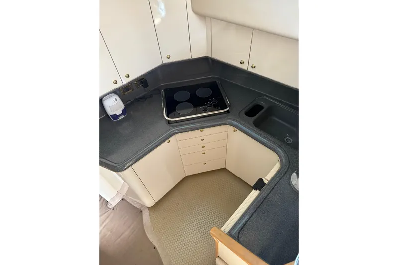 Slide: The Image of Compact kitchen in 1997 Sea Ray 370 Aft Cabin with stove and sink. - 31