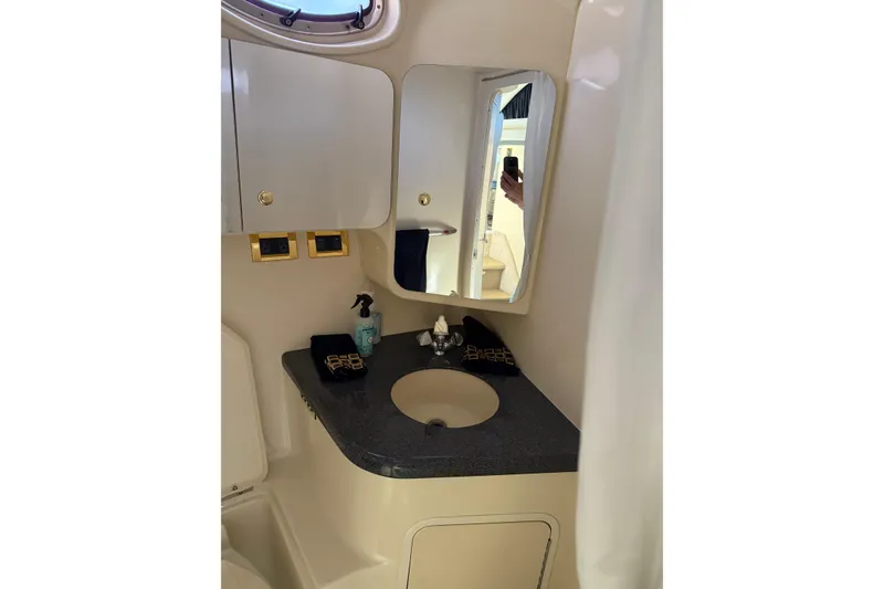 Slide: The Image of 1997 Sea Ray 370 Aft Cabin bathroom with sink, mirror, and storage cabinets. - 36