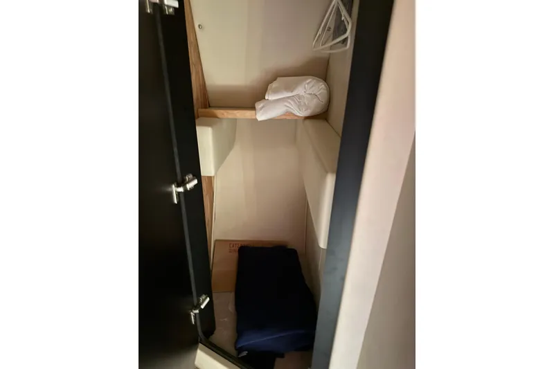 Slide: The Image of 1997 Sea Ray 370 Aft Cabin interior storage space with shelves and folded linens. - 39