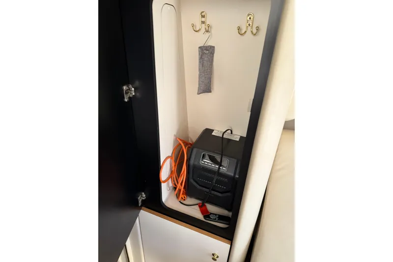 Slide: The Image of 1997 Sea Ray 370 Aft Cabin interior storage with hooks and electronic device. - 44