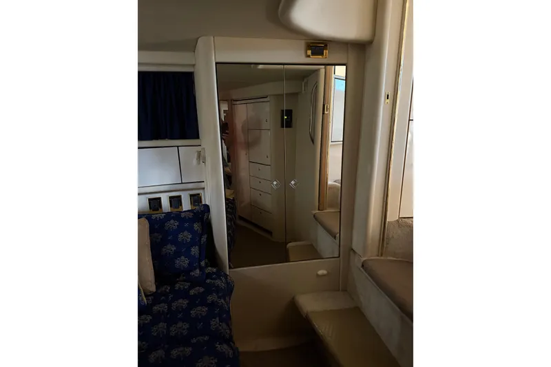 Slide: The Image of 1997 Sea Ray 370 Aft Cabin interior with mirrored closet and blue patterned seating. - 46