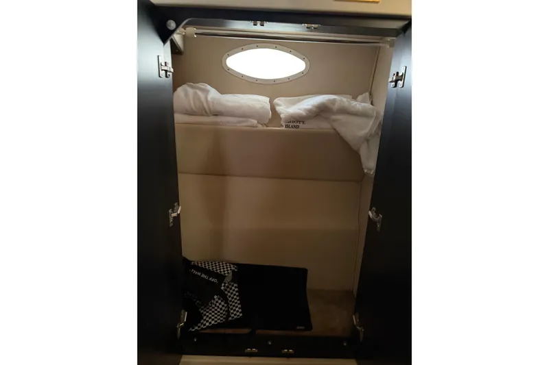 Slide: The Image of 1997 Sea Ray 370 Aft Cabin interior with cozy bedding and porthole window. - 47