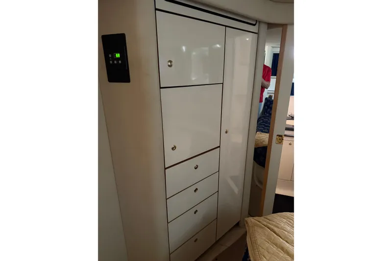 Slide: The Image of 1997 Sea Ray 370 Aft Cabin interior with white storage cabinets and digital control panel. - 48