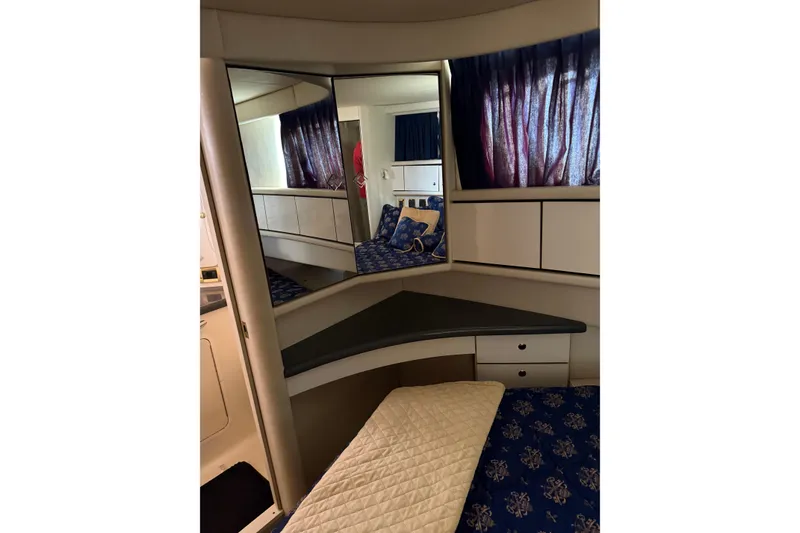 Slide: The Image of Interior of 1997 Sea Ray 370 Aft Cabin with mirrored vanity and blue curtains. - 50