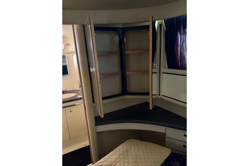 Slide: The Image of 1997 Sea Ray 370 Aft Cabin interior with open storage and cozy bedding. - 51