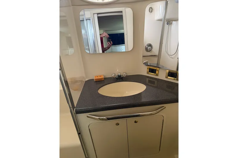 Slide: The Image of Bathroom vanity in 1997 Sea Ray 370 Aft Cabin yacht, featuring sink and mirror. - 52