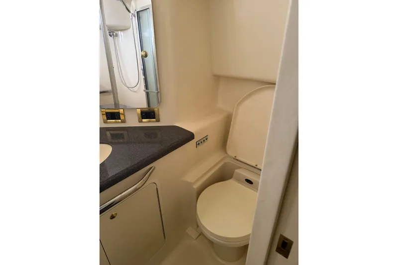 Slide: The Image of 1997 Sea Ray 370 Aft Cabin bathroom with toilet, sink, and mirror. - 53