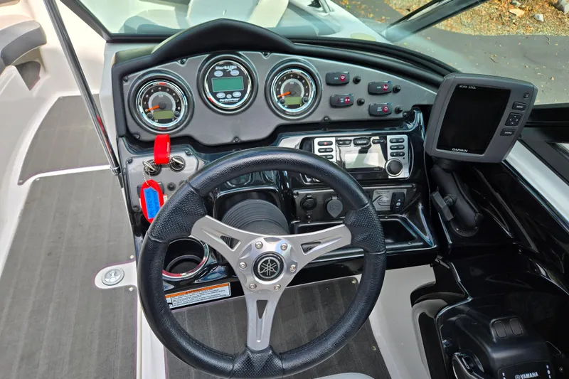 Slide: The Image of 2013 Yamaha Boats 212X dashboard with steering wheel, gauges, and Garmin navigation system. - 11