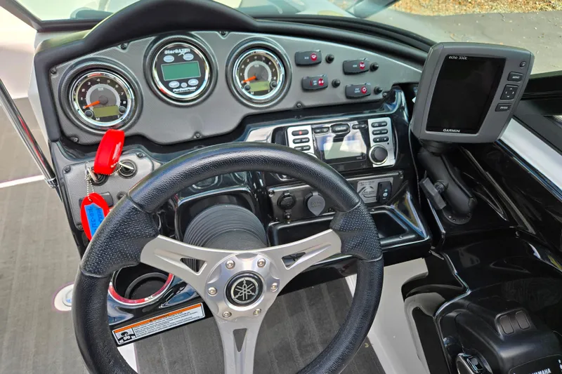 Slide: The Image of 2013 Yamaha Boats 212X dashboard with steering wheel, gauges, and Garmin navigation system. - 8