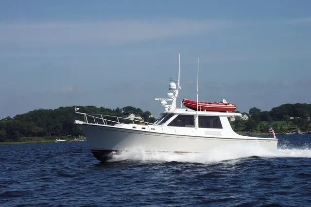 Slide: The Image of 2005 New England Boatworks Downeast Sedan cruising on open water. - 1