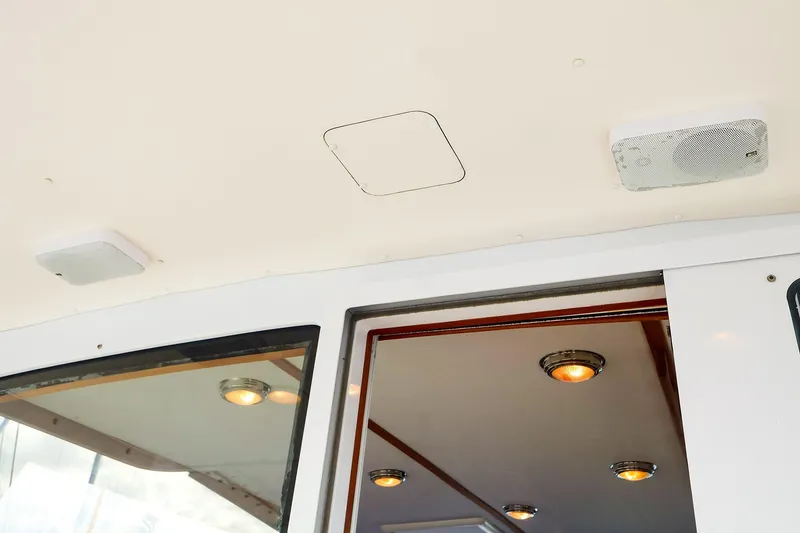 Slide: The Image of Interior view of 2005 New England Boatworks Downeast Sedan, featuring ceiling lights and speaker. - 10