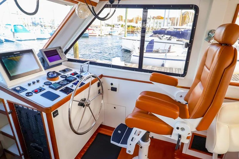 Slide: The Image of Helm of 2005 New England Boatworks Downeast Sedan with leather captain's chair and navigation equipment. - 11