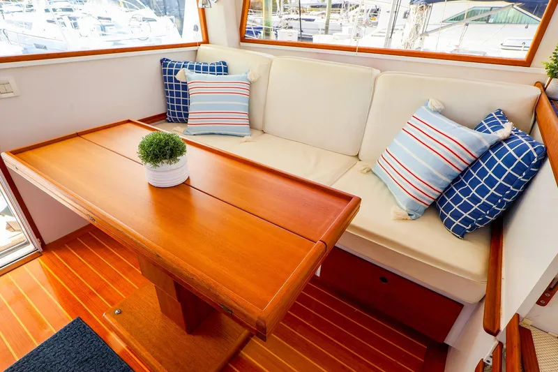 Slide: The Image of Interior of 2005 New England Boatworks Downeast Sedan with cozy seating and decorative pillows. - 28