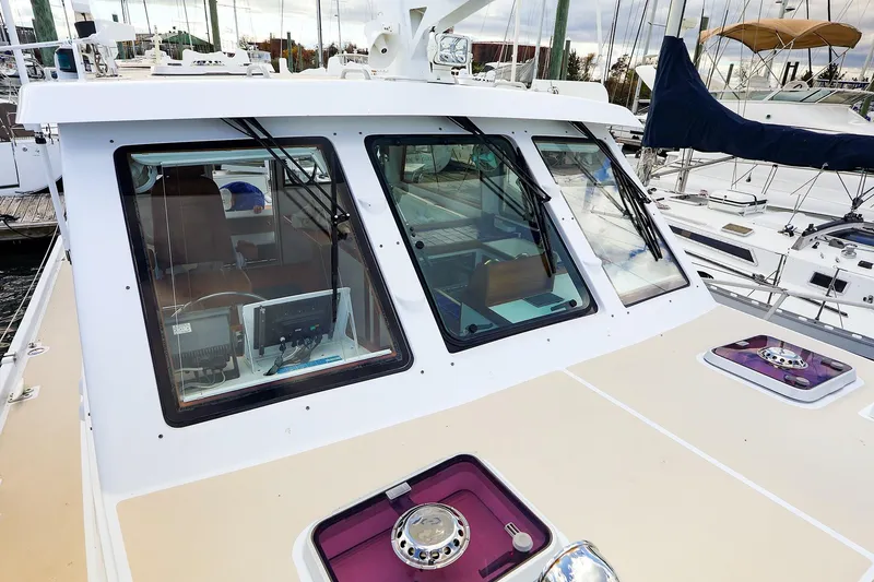 Slide: The Image of 2005 New England Boatworks Downeast Sedan with modern cockpit and marina view. - 3