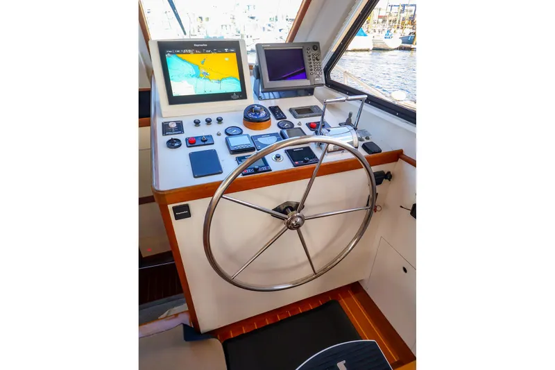 Slide: The Image of Helm of 2005 New England Boatworks Downeast Sedan with navigation equipment and steering wheel. - 15