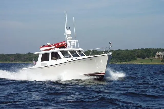 Slide: The Image of 2005 New England Boatworks Downeast Sedan cruising on open water. - 2