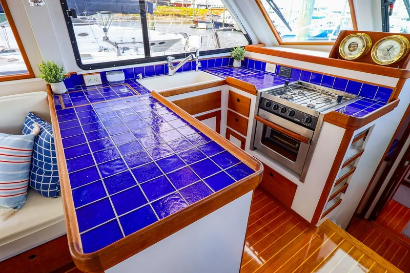 Slide: The Image of Luxurious 2005 New England Boatworks Downeast Sedan kitchen with blue tiled countertops. - 22