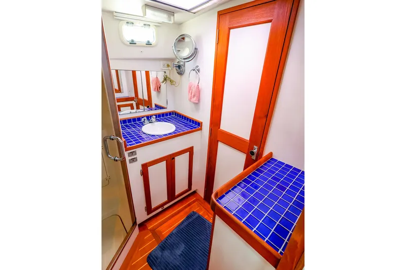 Slide: The Image of Luxurious 2005 New England Boatworks Downeast Sedan bathroom with blue tiled countertop. - 39