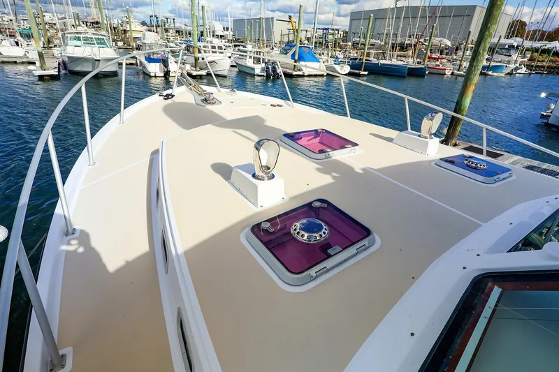 Slide: The Image of 2005 New England Boatworks Downeast Sedan docked at a marina, showcasing deck features. - 4