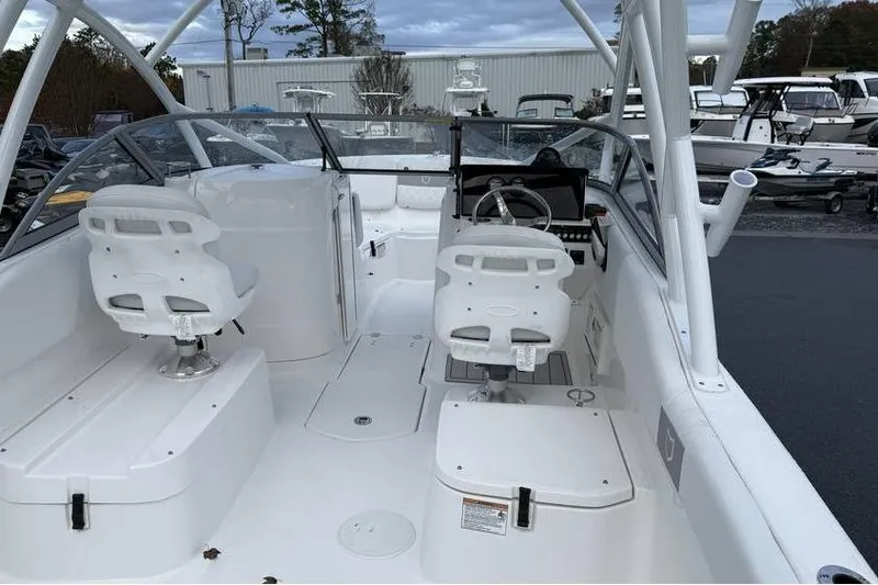 Slide: The Image of 2026 Sea Fox 228 Traveler boat interior with dual white captain chairs and sleek dashboard. - 11