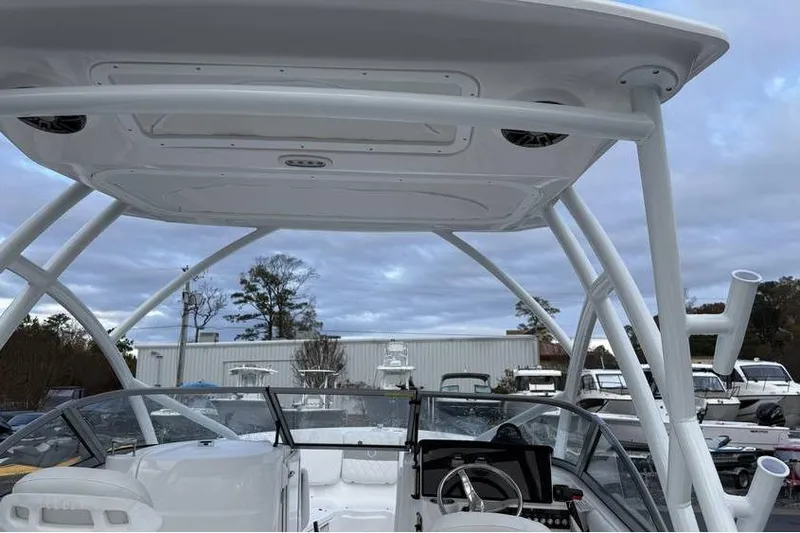 Slide: The Image of 2026 Sea Fox 228 Traveler boat with T-top and steering console, parked outdoors. - 12