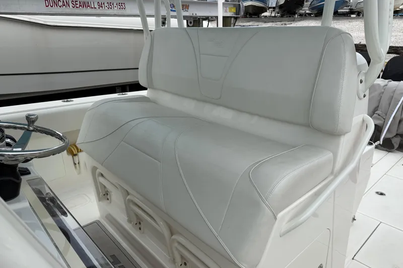 Slide: The Image of 2022 SeaVee 270Z boat interior with white cushioned seating and steering wheel. - 12