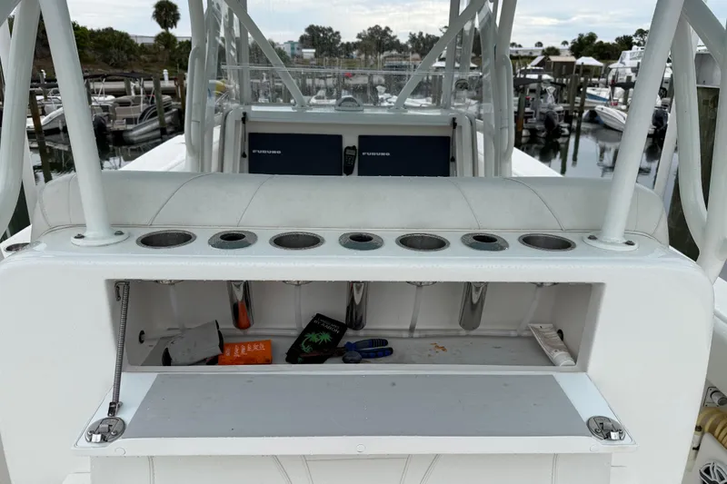 Slide: The Image of 2022 SeaVee 270Z boat with rod holders and storage compartment, docked at marina. - 18