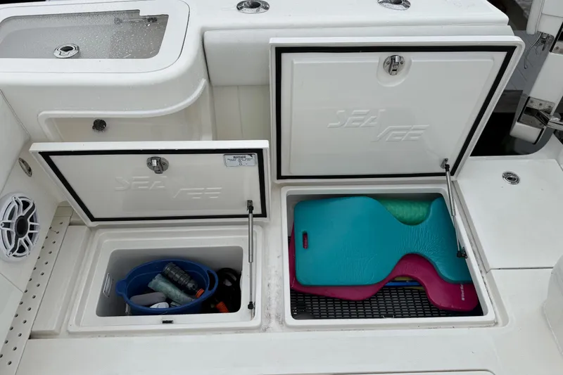 Slide: The Image of 2022 SeaVee 270Z boat storage compartments with gear and colorful mats. - 25