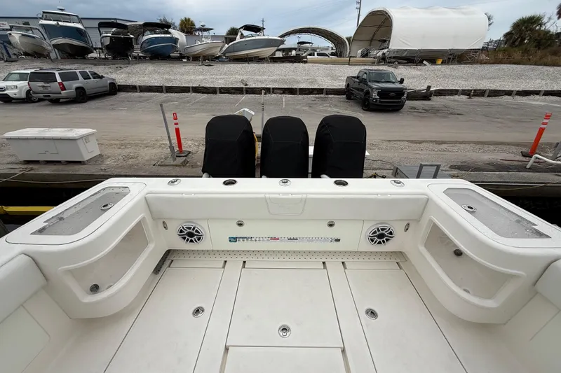 Slide: The Image of 2022 SeaVee 270Z boat with covered engines, docked near parked vehicles and other boats. - 29