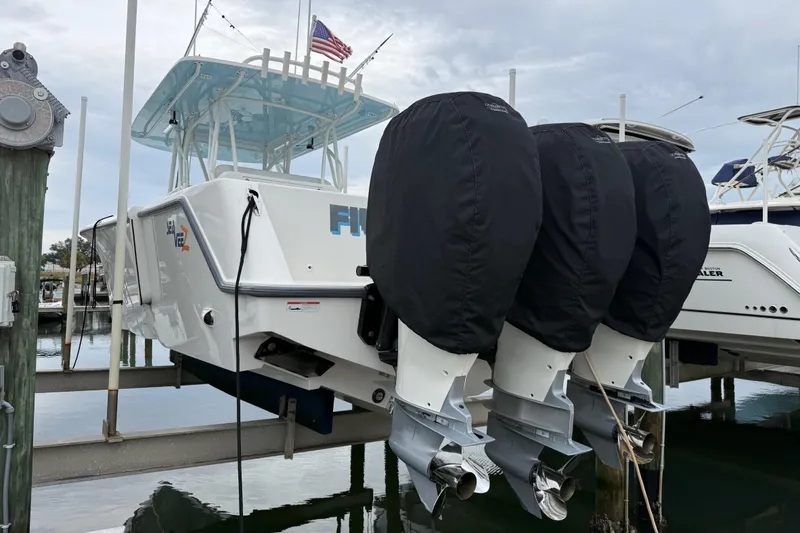 Slide: The Image of 2022 SeaVee 270Z boat with triple outboard motors docked at a marina. - 41