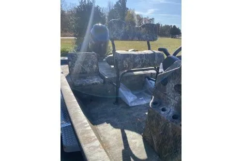 Slide: The Image of 2026 G3 Bay 19 GX boat interior with camo seats and console, outdoors. - 5