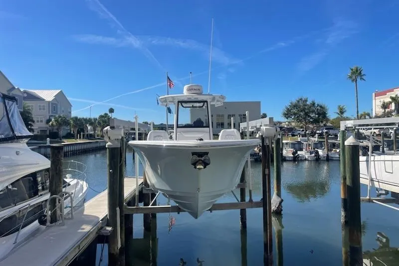 Slide: The Image of 2025 Sportsman Heritage 261 Center Console boat docked in a marina under clear blue skies. - 1