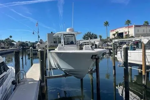 Slide: The Image of 2025 Sportsman Heritage 261 Center Console boat docked in a sunny marina. - 2