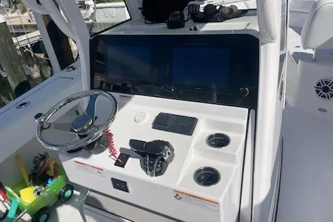 Slide: The Image of 2025 Sportsman Heritage 261 Center Console boat dashboard with steering wheel and controls. - 4