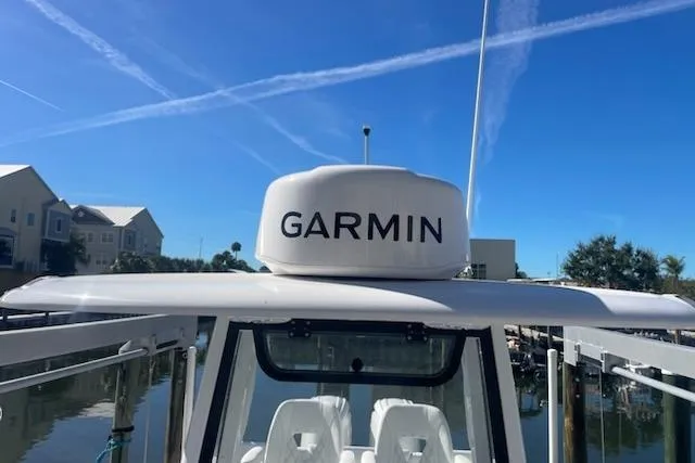 Slide: The Image of 2025 Sportsman Heritage 261 Center Console with Garmin radar, docked under clear blue sky. - 8