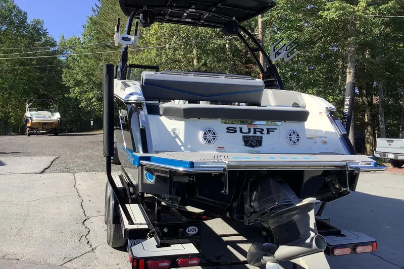 Slide: The Image of 2022 Cobalt R6 Surf boat on trailer, rear view, in outdoor setting. - 2